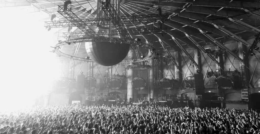 Crowd dancing at Awakenings Gashouder Amsterdam 2025, one of the biggest techno raves in the Netherlands, with a vibrant stage and light show.