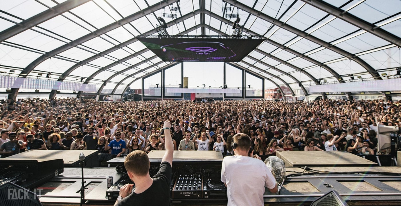 DGTL Festival 2025: A vibrant crowd dances at an open-air stage in Amsterdam, surrounded by colorful art installations, sustainable decor, and a lively festival atmosphere.