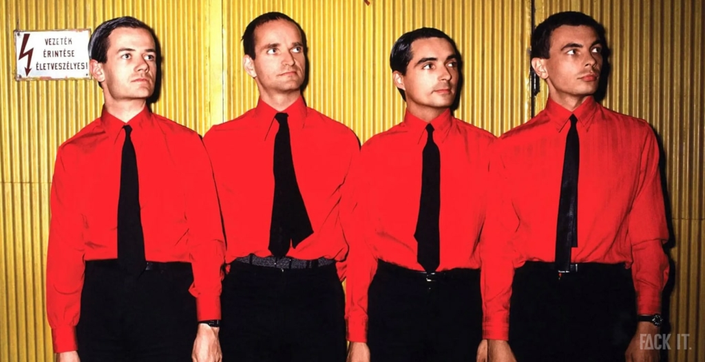 Kraftwerk, the pioneering electronic music group, posing in a futuristic setting with a signature robotic aesthetic, reflecting their influence on the origins of techno music.