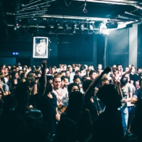A euphoric crowd dances under flashing strobe lights in a dark club during a Fack It night in Tilburg.