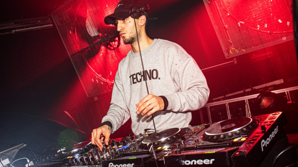 DJ Onedefined controls four decks, expertly blending tracks during a high-energy set.